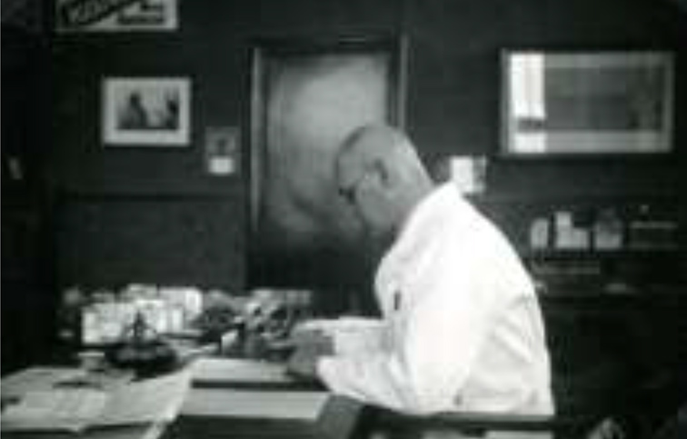 Carel Wilhelm Gersdorf (1894-1944) aan het werk in zijn kantoor van de Turmac (sigarettenfabriek) circa 1940.